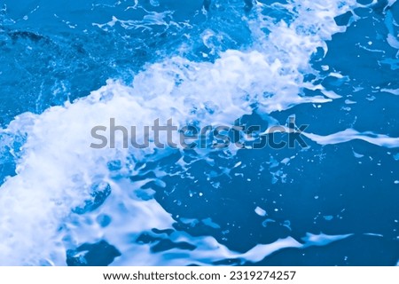 Close-up of water surface, where waves form intricate patterns and air bubbles rise, a refreshing and calming display of nature
