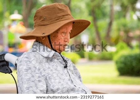 closed up old Asian grandpa sitting alone in the park Royalty-Free Stock Photo #2319277161