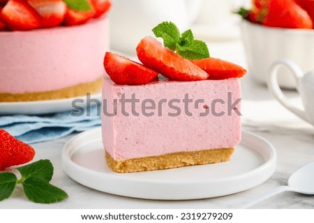 A slice of no bake strawberry cheesecake on a white plate. Close up. Selective focus Royalty-Free Stock Photo #2319279209