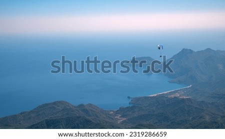 Paragliding over the sea and mountains.