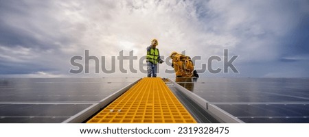 Specialist technicians engineer and Installation worker head to check quality of installing solar photovoltaic panels with technology tablet on center gable rooftop. Banner size with copy space. Royalty-Free Stock Photo #2319328475