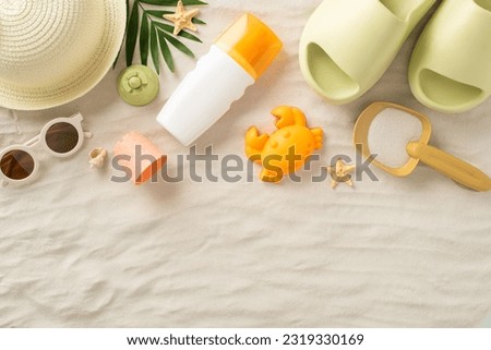 Summer escape with children concept. Top view photo of panama hat, kids' sand toys, palm leaves, seashells, sunscreen, flip-flops and sunglasses on an isolated sandy background with copyspace Royalty-Free Stock Photo #2319330169
