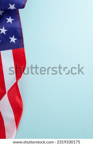 American federal holiday concept. High angle vertical view photo of the flag of United States of America on light blue isolated background with copy-space