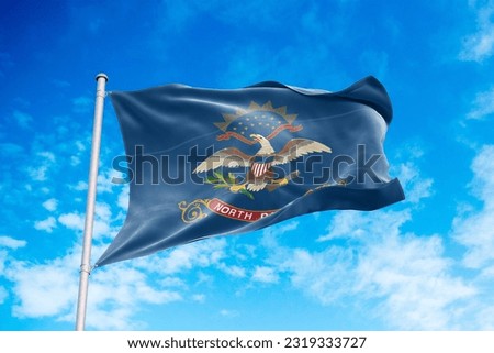 North Dakota flag waving in the wind, blue sky background