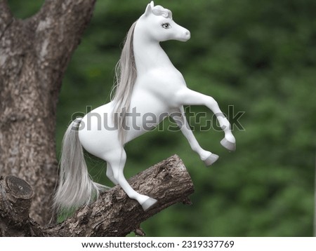 a toy horse hung on a tree for decorative purposes