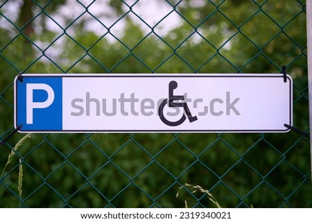 Disabled parking sign on a fence.                               