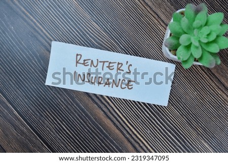 Concept of Renter's Insurance write on sticky notes isolated on Wooden Table.