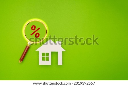 Home loan concept. Property investment and house mortgage financial. House symbol and a magnifying glass with a percent symbol are on a green background. Space for text