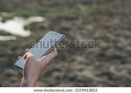 Traveler woman using smartphone during her travel on the beach nature vacation