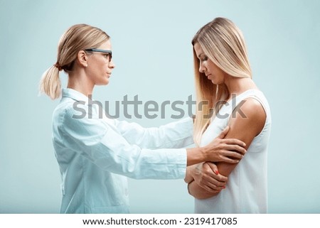 A blonde patient with her blonde doctor, possibly a gynecologist, psychiatrist, or family doctor. The doctor, caring for both the physical and emotional health of her patient, has earned her trust Royalty-Free Stock Photo #2319417085