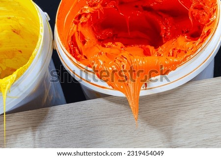 
Orange paint dripping from white barrel.
plastisol ink is used for printing on fabrics because it is durable,
 easily cured and can be stretched without cracking or becoming distorted.
