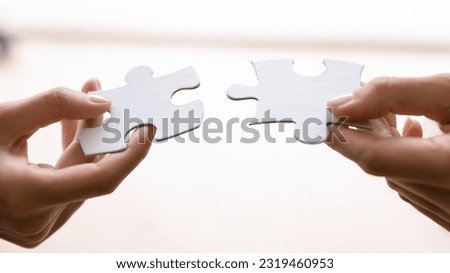 Human connecting two pieces of puzzle. Woman joining jigsaw parts. Business person offering great solution for client needs, finding best problem solving. Perfect match in partnership concept Royalty-Free Stock Photo #2319460953
