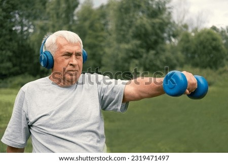 Senior man working out outdoors. Person lifting dumbbells. Old male exercising at park. Healthy people lifestyle. Active sport training. Older elderly sportsman doing fitness exercise. Workout session Royalty-Free Stock Photo #2319471497