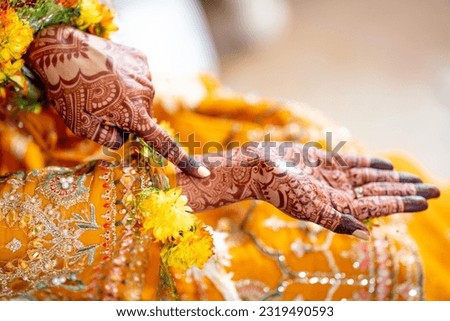 A woman with henna mehendi on her hands in her haldi ceremony. 
Indian bride showing hands mehndi design Royalty-Free Stock Photo #2319490593