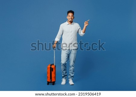 Full body fun traveler man wear casual clothes shirt hold suitcase isolated on dark royal navy blue background. Tourist travel abroad in free spare time rest getaway. Air flight trip journey concept