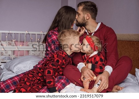 happy family with children, parents and daughter and son kissing.