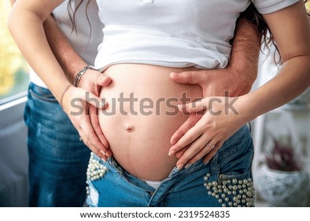 Pregnancy. Future parents make a heart on their tummy. Waiting. Baby. High quality photo