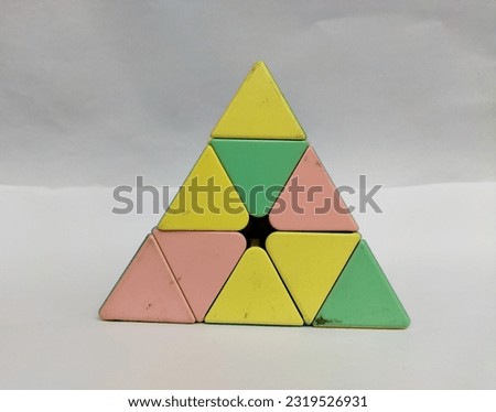 Pyramid-shaped rotating toy, Rubik's Cube triangle or pyraminx meilong with macaroon color to train brain speed thinking, dengan background putih..

￼



