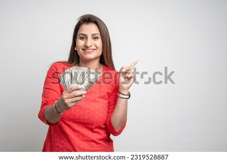 Indian woman showing five hundred bank and giving happy expression.