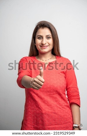 Confident woman showing thumbs up on white background. Royalty-Free Stock Photo #2319529349
