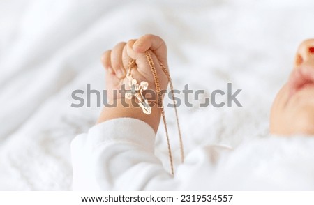 The sacrament of the baptism of a child. The kid is holding a cross. Selective focus. People. Royalty-Free Stock Photo #2319534557