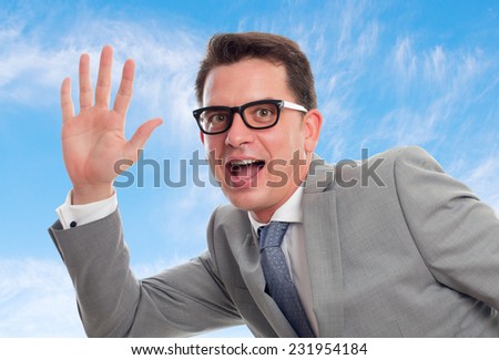 Young business man with grey suit over clouds background. Showing his palm