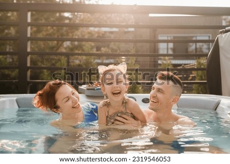 In summer, the family rests in the outdoor hot tub. Royalty-Free Stock Photo #2319546053