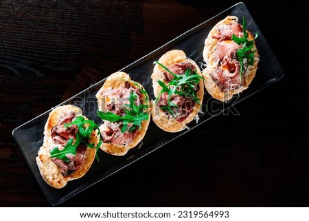 bruschetta with roast beef and cheese on plate Royalty-Free Stock Photo #2319564993