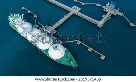 LNG (Liquified Natural Gas) tanker anchored in Gas terminal gas tanks for storage. Oil Crude Gas Tanker Ship. LPG at Tanker Bay Petroleum Chemical or Methane freighter export import transportation  Royalty-Free Stock Photo #2319571485