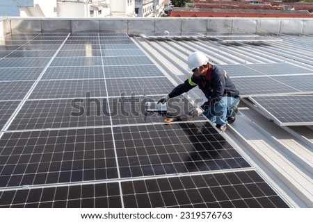 Engineer working to inspect equipment in rooftop solar power plant, solar panel maintenance installation view Royalty-Free Stock Photo #2319576763