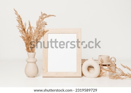 Wooden mockup photo frame with ceramic vases set, candle and pampas grass. Picture frame with copy space for poster and design, cozy scandinavian home interior style	