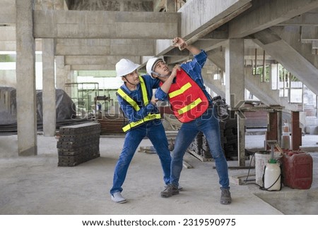 concept occupational risk management in industry,workplace safety.senior help young man worker that small log is being fallen near hit his head,engineer team working in the building under construction Royalty-Free Stock Photo #2319590975