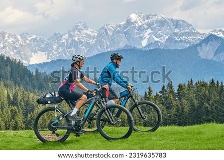 active senior couple on a mountain bike tour in the Julian Alps above Kranska Gora in Slovenia Royalty-Free Stock Photo #2319635783