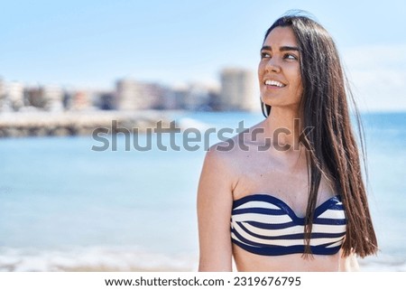 Young hispanic woman smiling confident wearing bikini at seaside