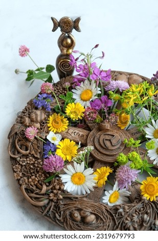 Altar for Summer solstice, Litha wiccan holiday. wheel of the year with colorful flowers and triple Goddess statue on table, abstract background. symbol of celtic wiccan sabbat, summer season Royalty-Free Stock Photo #2319679793
