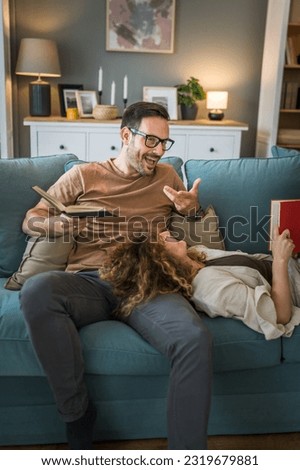 Adult couple man and woman Caucasian husband and wife in a relationship real book hold books on the sofa bed at home in the apartment reading leisure bonding family concept real people copy space Royalty-Free Stock Photo #2319679881