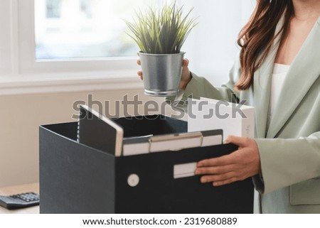 young employee packing her stuff on the desk in office to leaving work. person resigned from company to change job for promoted. Royalty-Free Stock Photo #2319680889