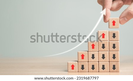 Rising and falling arrow trend. Up and down point arrow on wooden cube block for stock economic and business profit growth and loss concept. Copy space