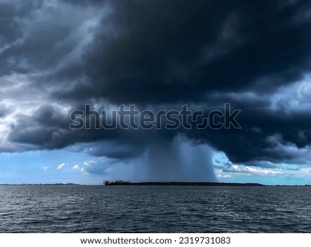 Dramatic rain storm over a small island in the ocean