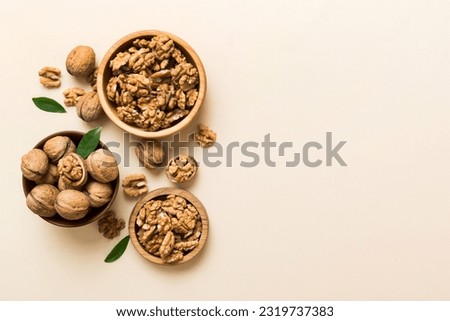 Walnut kernel halves, in a wooden bowl. Close-up, from above on colored background. Healthy eating Walnut concept. Super foods with copy space. Royalty-Free Stock Photo #2319737383