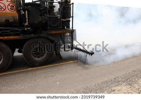 Tarring or ashpalting machines laying new surfaces on a road  Royalty-Free Stock Photo #2319739349