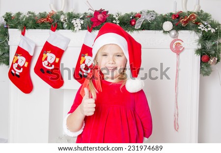 beautiful girl stands near the fireplace Christmas decorations and smiling