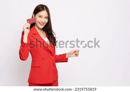 Young beautiful Asian business woman in red suit smiling holding credit card isolated on white background Royalty-Free Stock Photo #2319755819