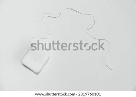 Container with dental floss on white background. White dental floss case. Open dental floss container