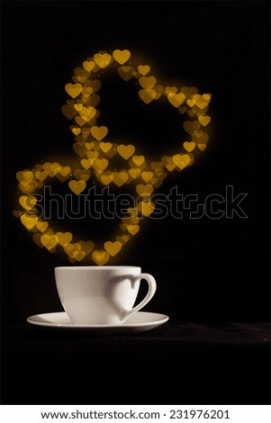Cup with fantasy golden double heart shape steam on dark background