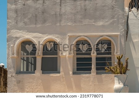The symbol of hearts on the windows of an old house as an example of creating a romantic atmosphere inside the house and for decorating the facade of the building. Creating memorable images