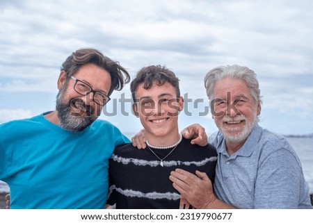 Three generations of family men, hugging smiling happy, father, teenage son and grandfather. Handsome people relaxing together Royalty-Free Stock Photo #2319790677