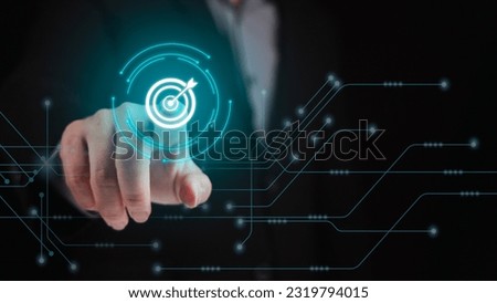 Businessman hand pointing his finger at virtual screen with arrow icon in dark background. Business plan, strategy, goal, sale target, project objective concept. Royalty-Free Stock Photo #2319794015