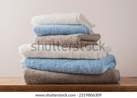 Stack of blue white beige cotton terry towels close up view. Bathroom interior details with copy space Royalty-Free Stock Photo #2319806309
