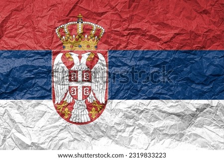 Flag of Serbia on crumpled paper. Textured background.